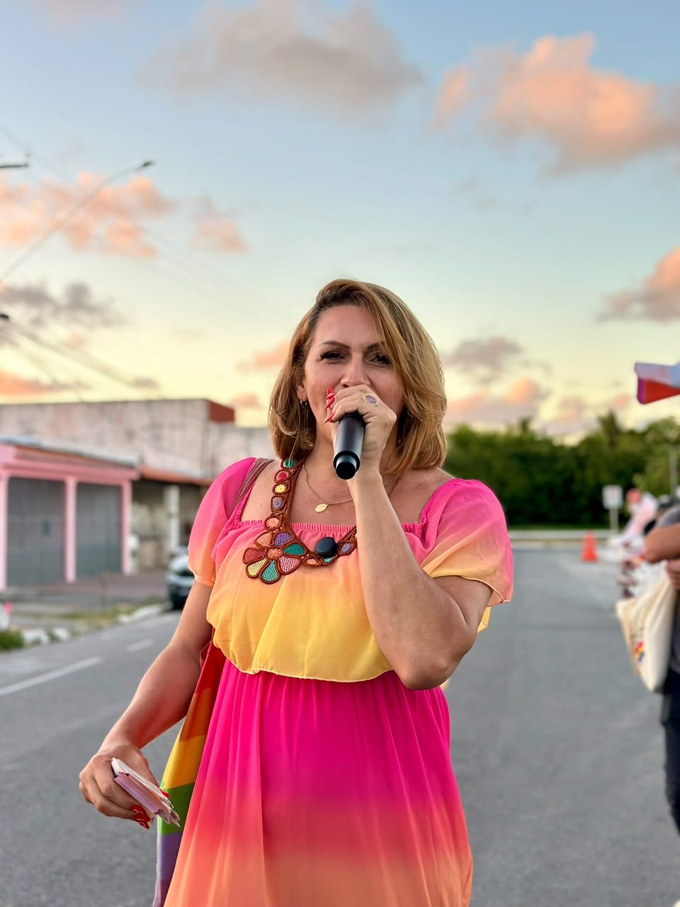 Linda Brasil fala ao microfone no fim da tarde durante caminhada em bairro de Aracaju