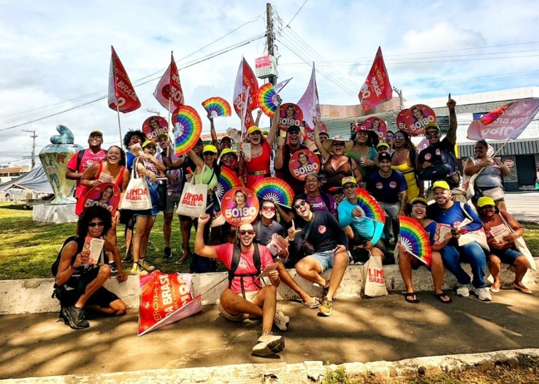 Linda Brasil e dezenas de apoiadores com bandeiras, leques coloridos e materiais da campanha 50180 no bairro Bugio