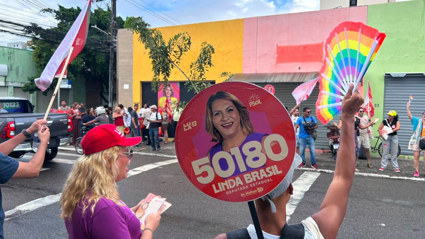 Apoiador ergue leque circular da campanha 50180 de Linda Brasil em frente ao comitê, no centro de Aracaju